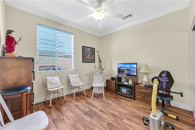 living area with crown molding, hardwood / wood-style floors, and ceiling fan