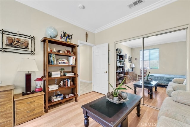 living room with wood-type flooring and ornamental molding