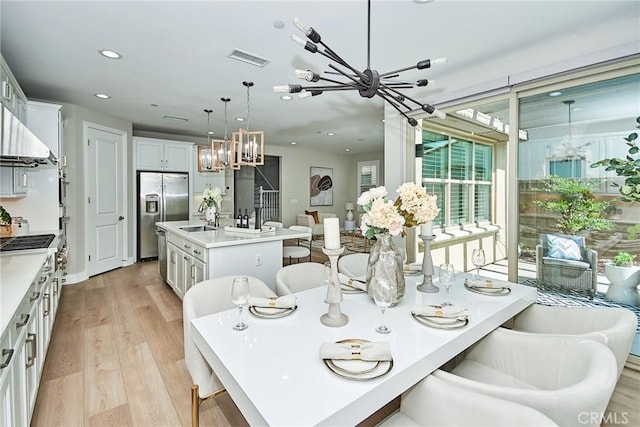 dining space with stairs, light wood-type flooring, visible vents, and recessed lighting