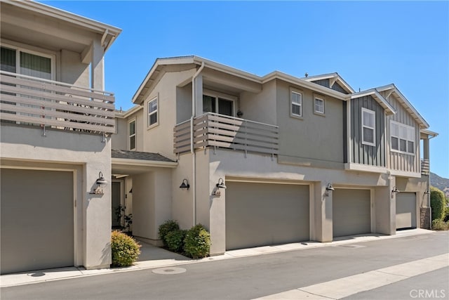 townhome / multi-family property featuring a balcony and a garage