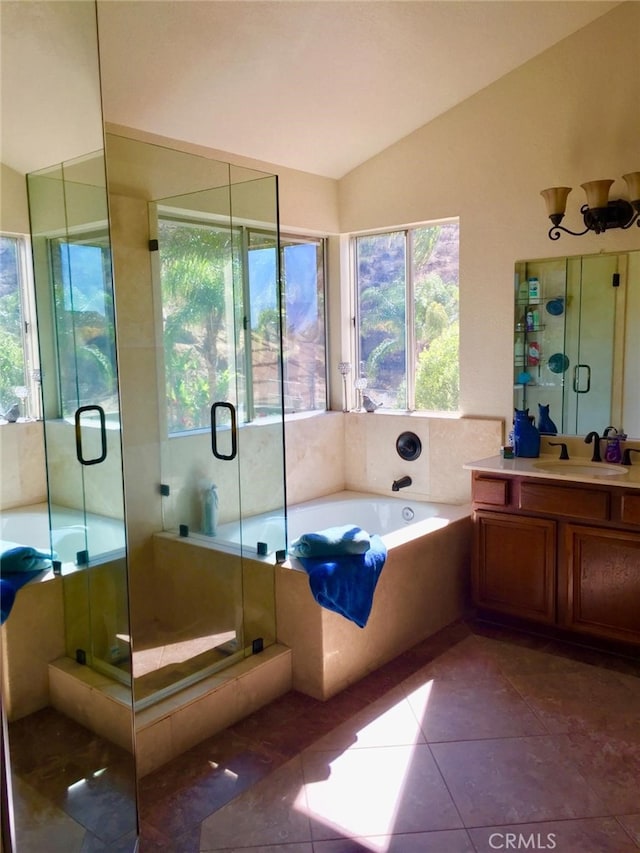 bathroom with vanity, plenty of natural light, separate shower and tub, and vaulted ceiling