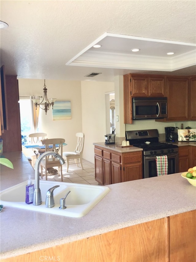 kitchen with sink, a textured ceiling, stainless steel appliances, and a raised ceiling