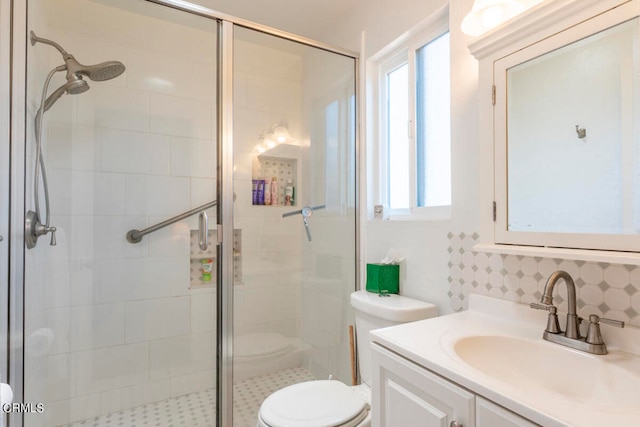 bathroom featuring a wealth of natural light, vanity, a shower with shower door, and toilet