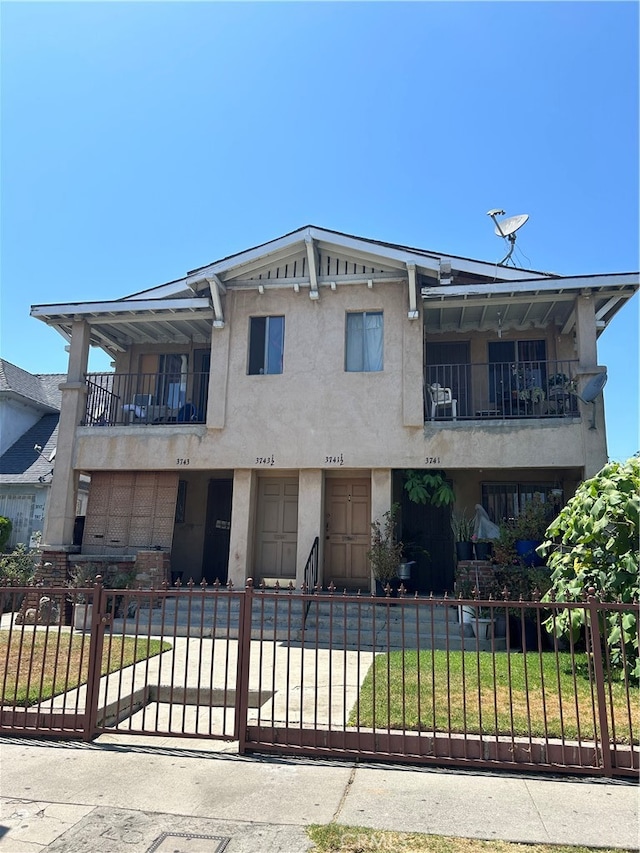 view of front of home featuring a balcony and a front yard