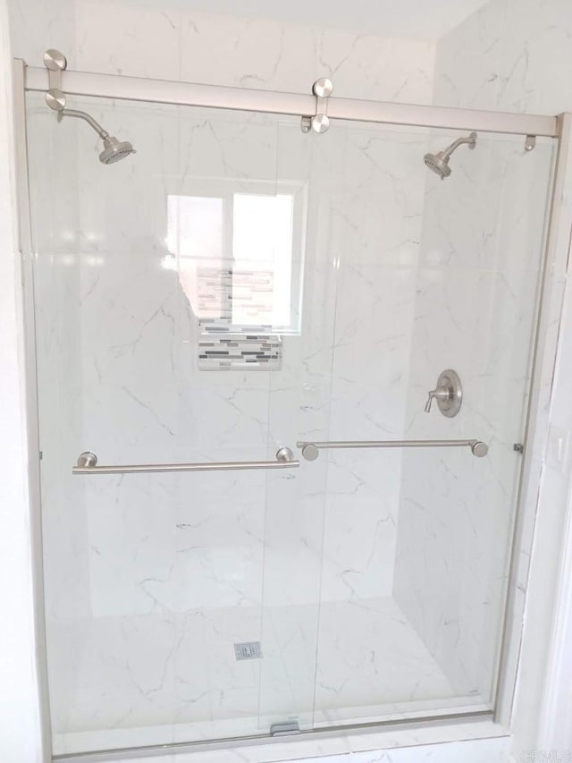 bathroom featuring a shower with door