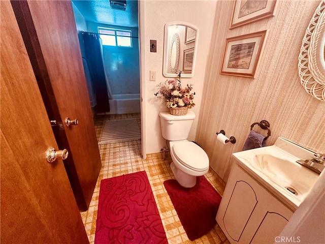 bathroom featuring vanity, curtained shower, and toilet