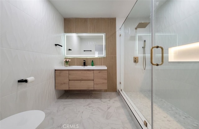 bathroom with walk in shower, tile walls, and vanity