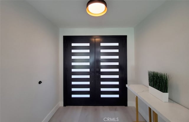 entrance foyer with french doors and light hardwood / wood-style flooring