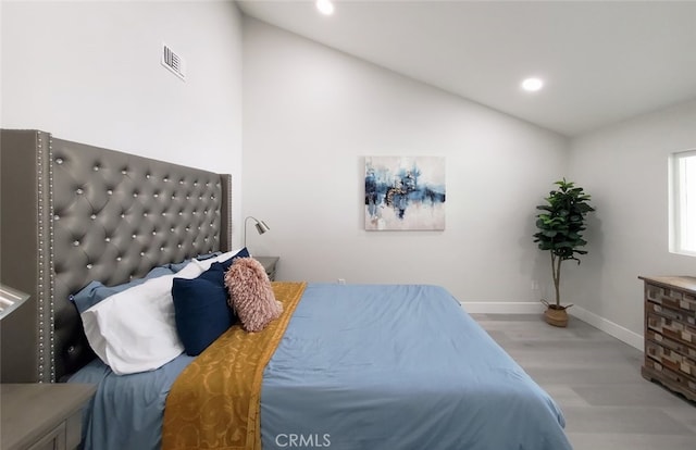 bedroom with lofted ceiling and light hardwood / wood-style flooring