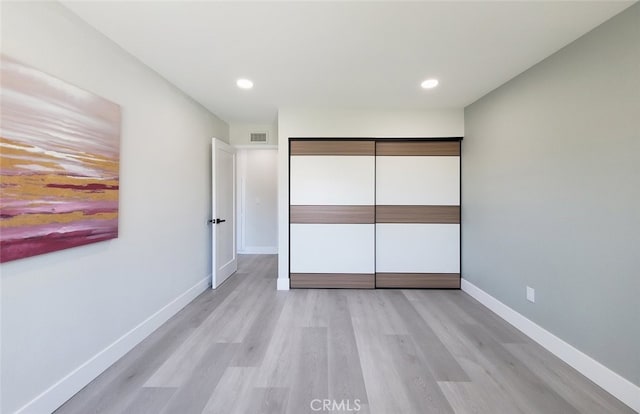 unfurnished bedroom featuring a closet and light hardwood / wood-style floors