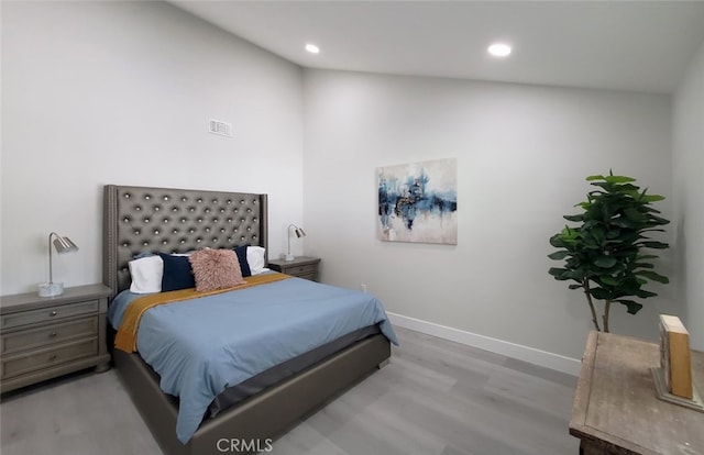 bedroom with lofted ceiling and light hardwood / wood-style floors