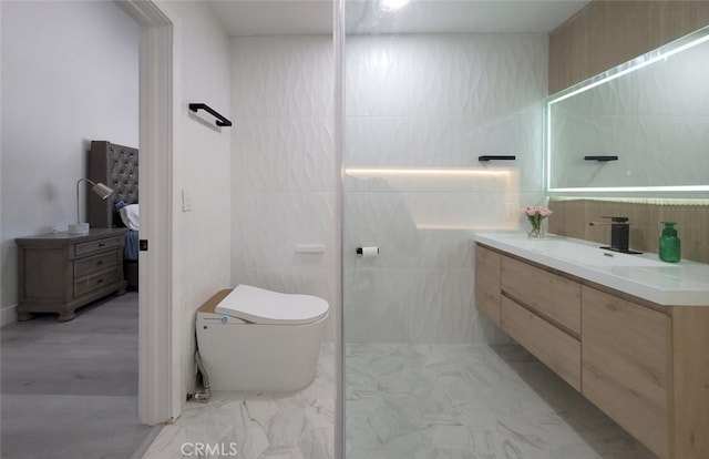 bathroom with tile walls, vanity, and toilet