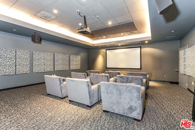 carpeted home theater with a tray ceiling and a drop ceiling