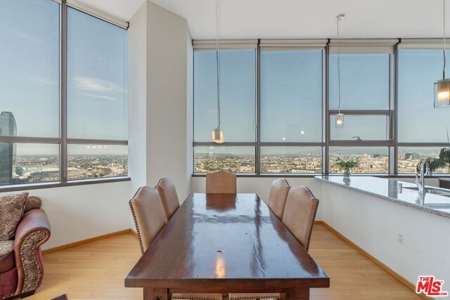 dining area with light wood-type flooring and sink