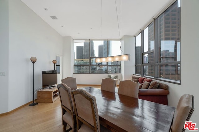 dining area featuring light hardwood / wood-style floors and a wall of windows