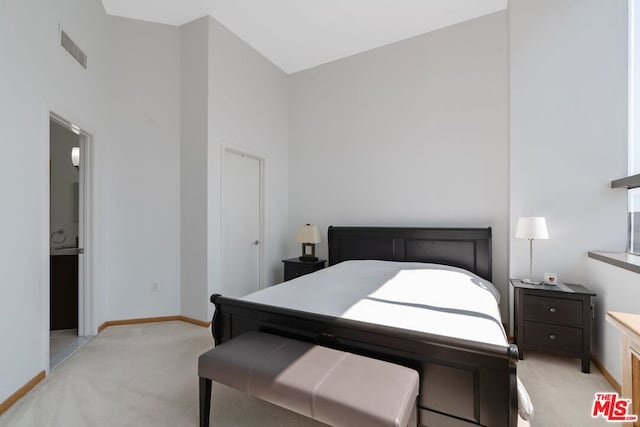 bedroom featuring light colored carpet and a high ceiling