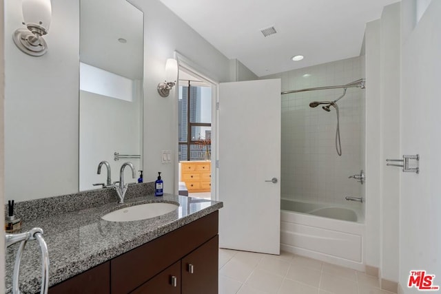 bathroom with tiled shower / bath, tile patterned flooring, and vanity