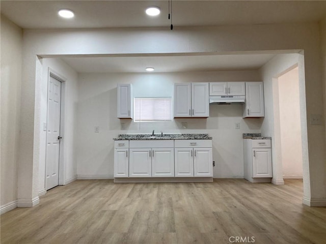 kitchen featuring white cabinetry, sink, and light hardwood / wood-style flooring