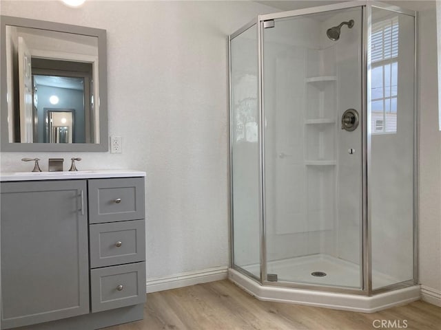 bathroom with hardwood / wood-style floors, vanity, and walk in shower