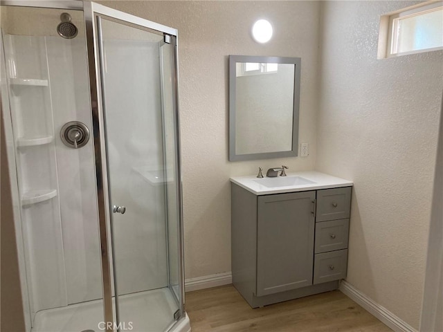 bathroom with hardwood / wood-style flooring, vanity, and an enclosed shower