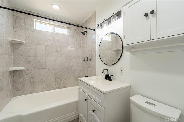 full bathroom with toilet, vanity, and tiled shower / bath