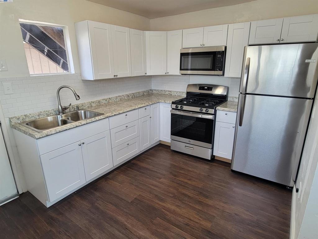 kitchen with white cabinets, backsplash, dark hardwood / wood-style flooring, stainless steel appliances, and sink