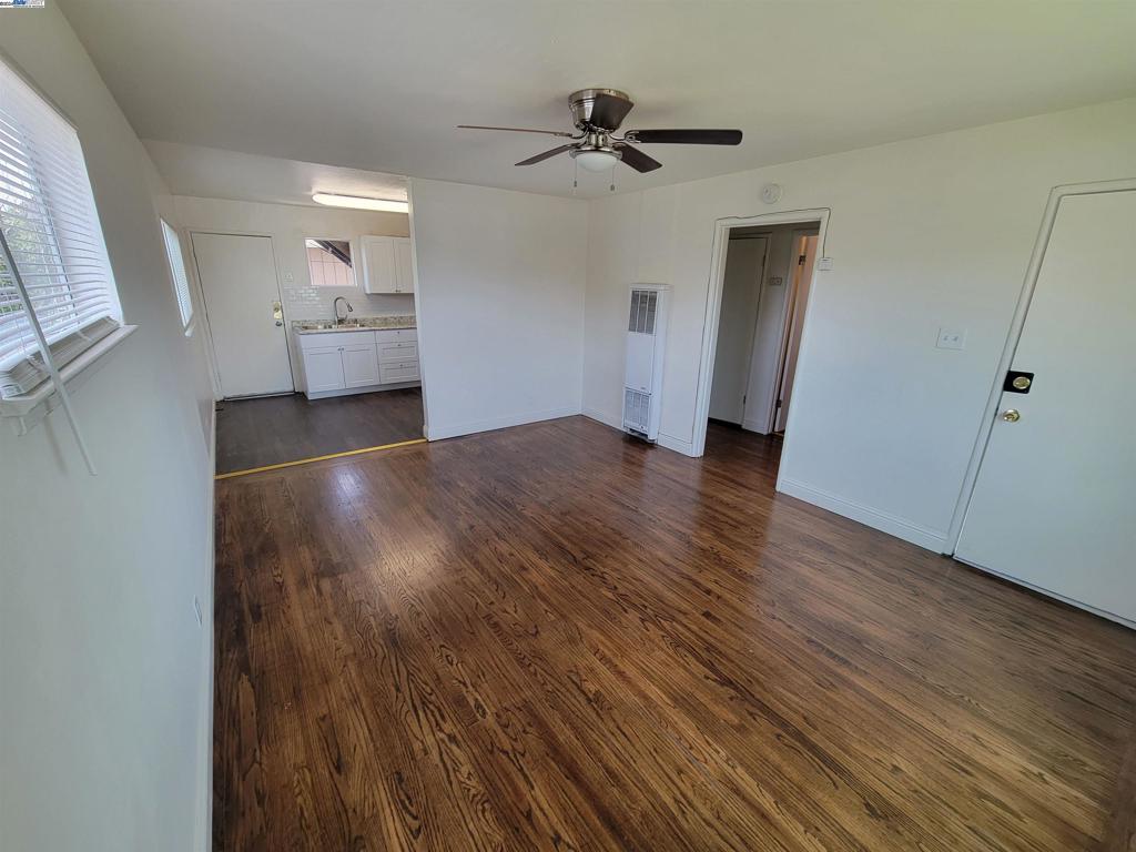 unfurnished living room featuring sink, dark hardwood / wood-style floors, and ceiling fan