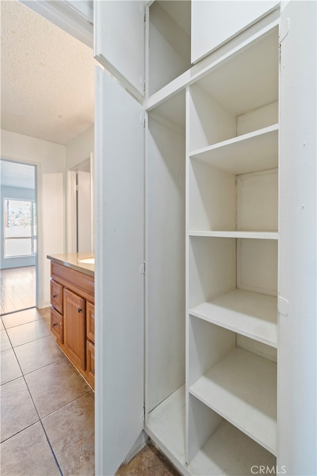 interior space with vanity, tile patterned flooring, and a textured ceiling