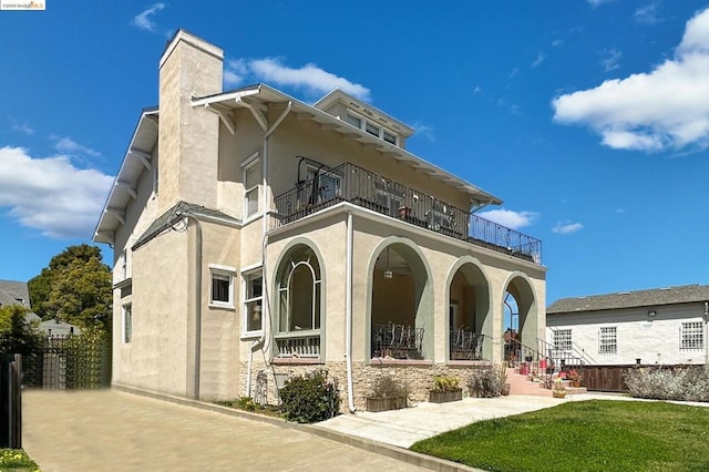 exterior space featuring a balcony and a yard