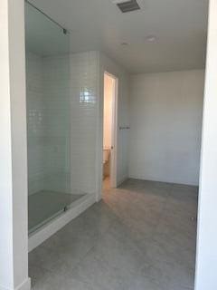 bathroom featuring tiled shower and concrete floors