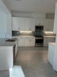 kitchen featuring sink, white cabinetry, and stainless steel appliances