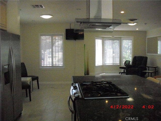 kitchen with island exhaust hood, light tile patterned floors, and stainless steel fridge with ice dispenser