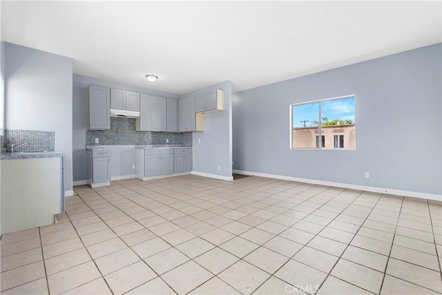 10406 Avalon Blvd, Los Angeles, CA 90003 - kitchen featuring decorative backsplash, light tile patterned floors, and gray cabinetry