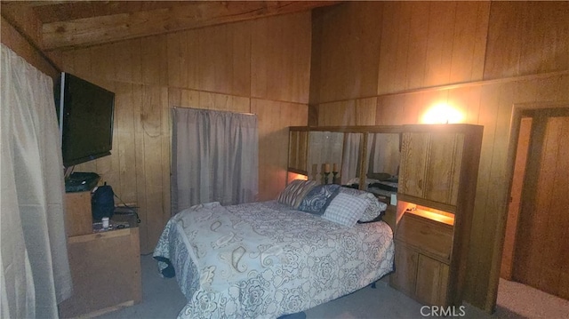 bedroom with carpet floors and wood walls