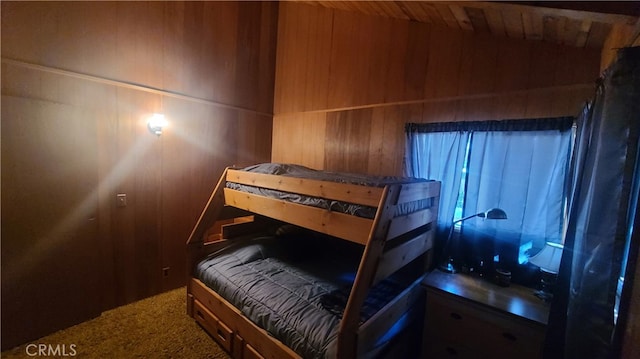 bedroom featuring wood walls and carpet flooring