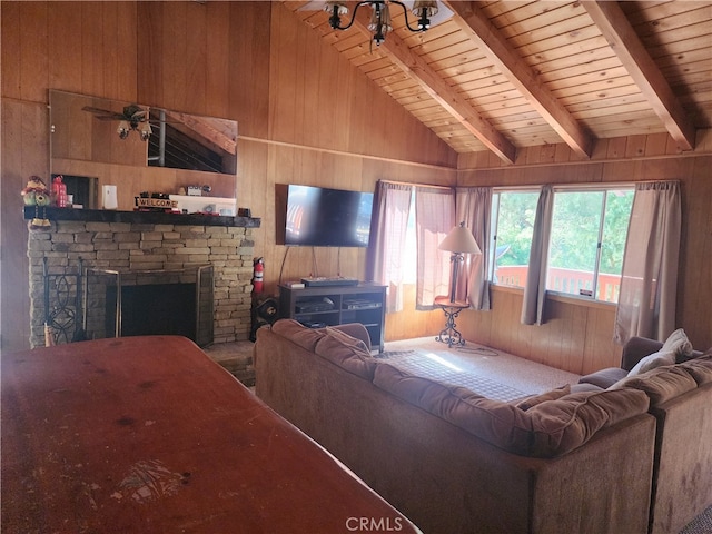 living room with wooden walls, ceiling fan, wooden ceiling, a fireplace, and lofted ceiling with beams