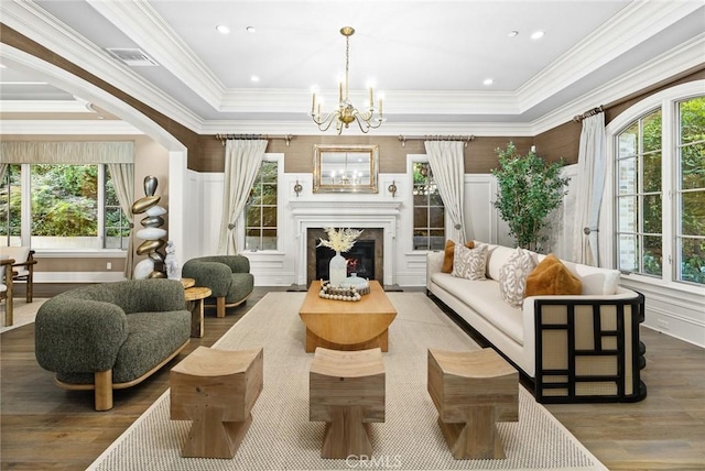 interior space featuring hardwood / wood-style flooring, a high end fireplace, a chandelier, and ornamental molding