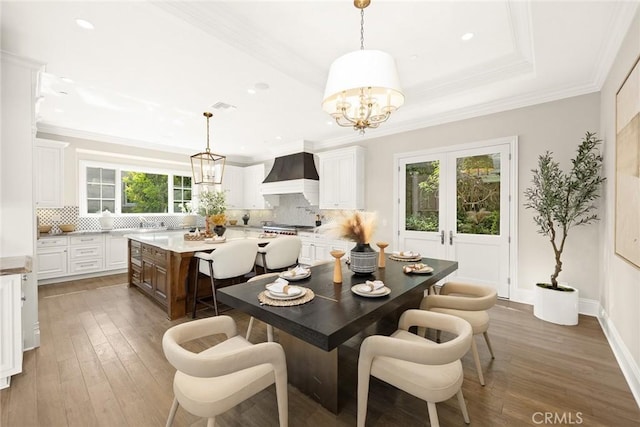 dining room featuring a chandelier, crown molding, and dark wood-type flooring