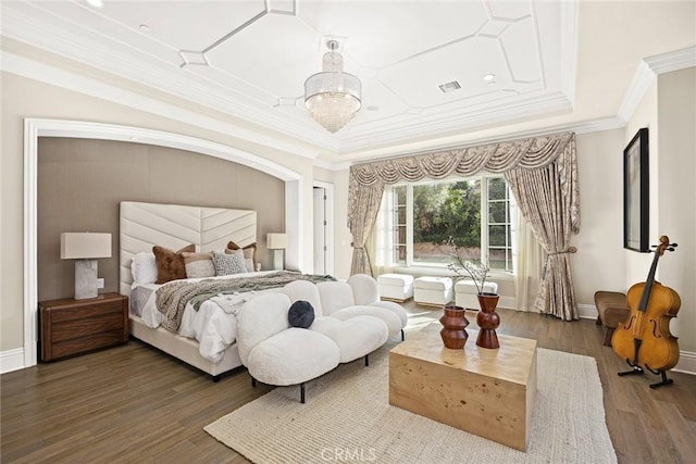 bedroom featuring hardwood / wood-style flooring, a tray ceiling, crown molding, and a notable chandelier