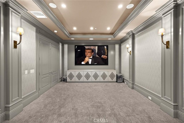 carpeted cinema room with a raised ceiling and crown molding