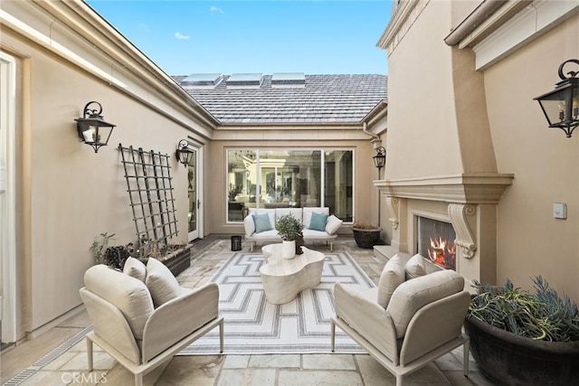 view of patio featuring an outdoor living space with a fireplace