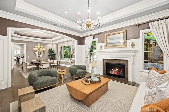 living room with a wealth of natural light, a tray ceiling, and dark hardwood / wood-style floors