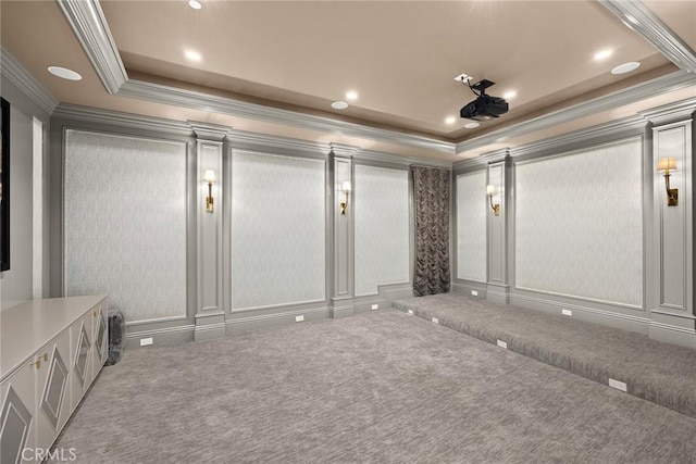 carpeted cinema room featuring a raised ceiling and crown molding