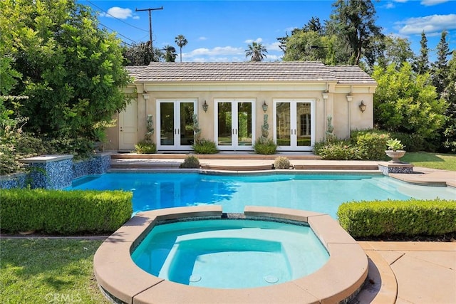 view of pool with an outbuilding, an in ground hot tub, and french doors