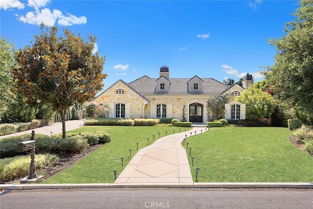 french country inspired facade featuring a front lawn