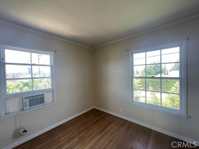 empty room with cooling unit, crown molding, dark hardwood / wood-style floors, and a healthy amount of sunlight