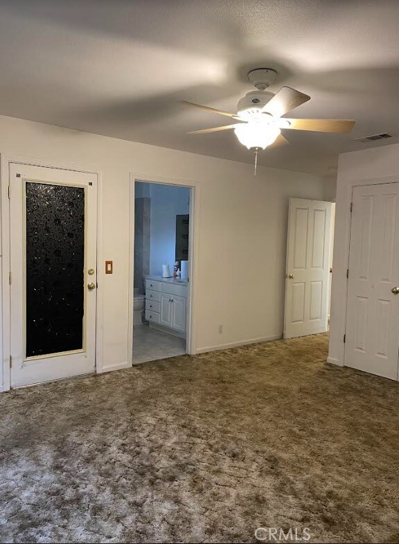 unfurnished room with ceiling fan and carpet floors