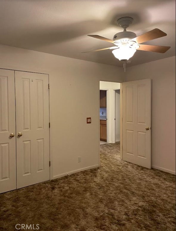 unfurnished bedroom with a closet, ceiling fan, and carpet floors