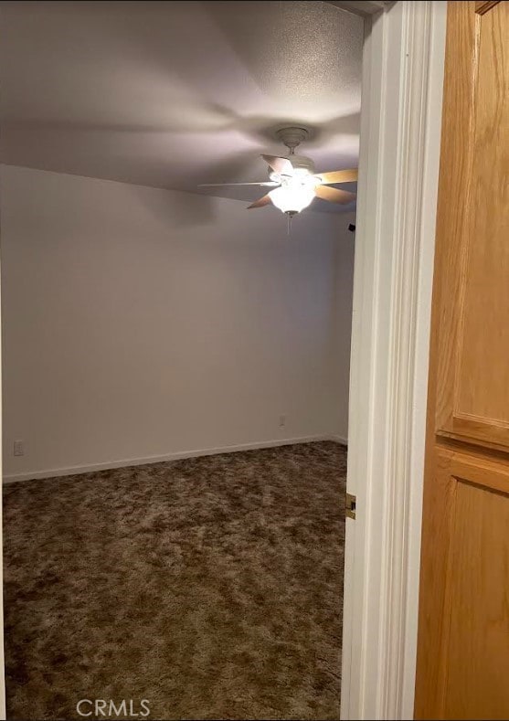 carpeted spare room with ceiling fan and a textured ceiling