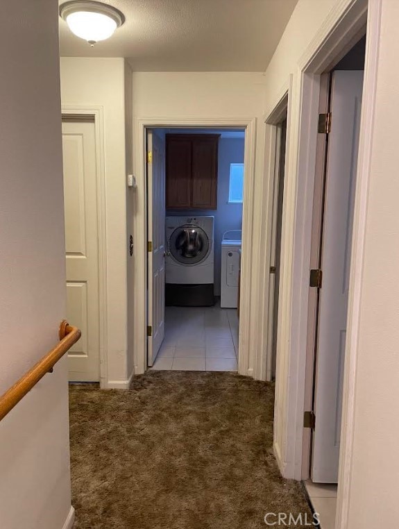 hallway featuring washing machine and dryer and light carpet